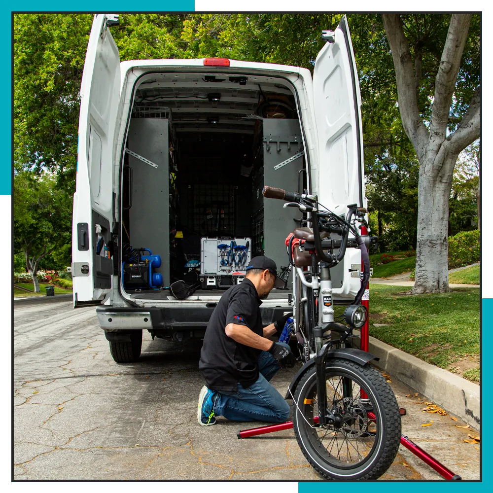 Mobile bike mechanic repairing an ebike at a customer's house.