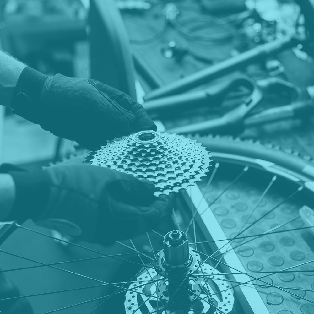 Bike mechanic assembling a bicycle gear shifter.